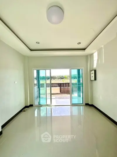 Spacious living room with large sliding glass doors leading to a balcony with scenic views.