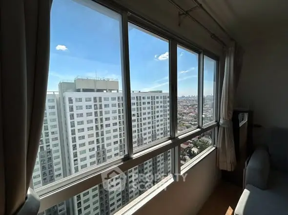 Stunning high-rise apartment with panoramic city views through large windows, offering abundant natural light.