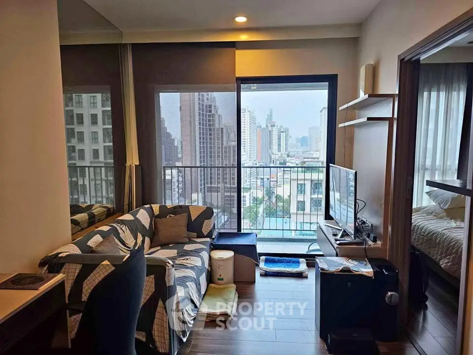 Modern living room with city view, cozy seating, and adjacent bedroom in urban apartment.
