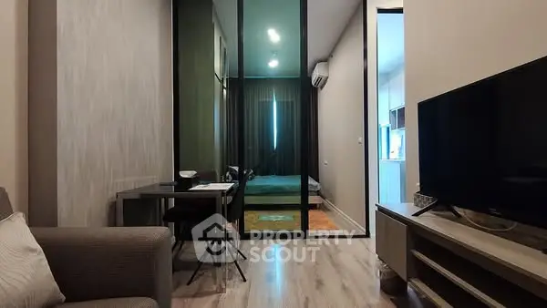 Modern apartment interior with glass partition, cozy living area, and stylish bedroom.