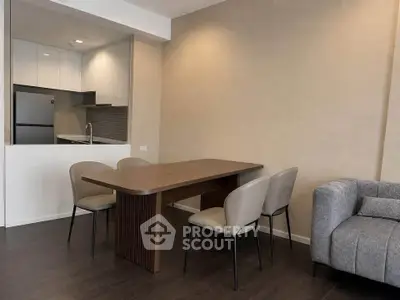 Modern open-layout kitchen and dining area with sleek furniture and neutral tones.