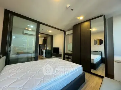 Modern bedroom with mirrored wardrobe and open view to living area