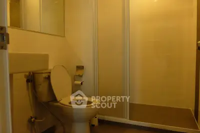 Modern bathroom with shower and toilet in warm lighting