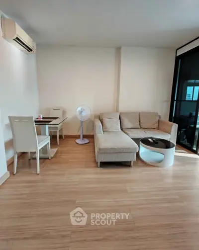 Modern living room with cozy sofa and dining area, featuring sleek wooden flooring.
