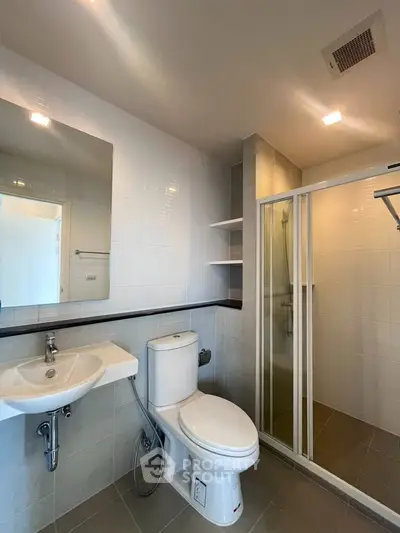 Modern bathroom with glass shower and sleek fixtures in a contemporary apartment.