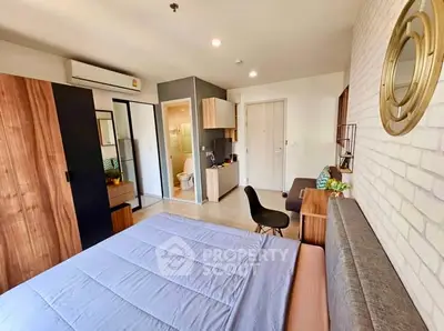 Modern bedroom with ensuite bathroom, stylish decor, and ample natural light.