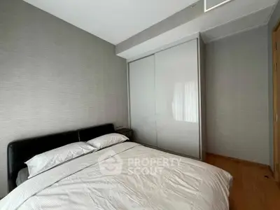 Modern bedroom with sleek design and ample natural light, featuring a comfortable bed and built-in wardrobe.