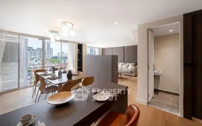Spacious modern living room with dining area and city view, featuring elegant decor and natural light.