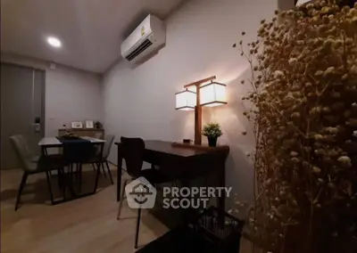 Cozy dining and study area with modern decor and warm lighting in a stylish apartment.