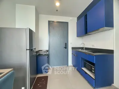 Modern kitchen with blue cabinets and sleek appliances in a stylish apartment