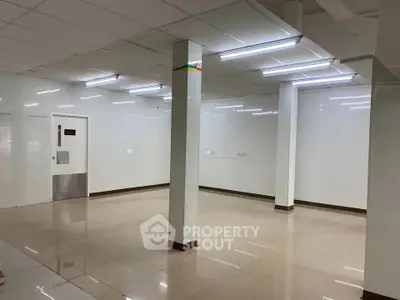 Spacious commercial space with tiled flooring and bright lighting, ideal for retail or office use.