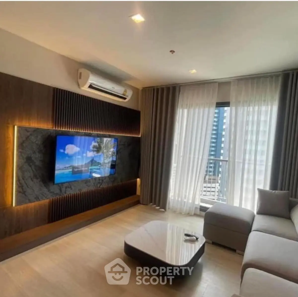 Modern living room with stylish decor and large window offering city view