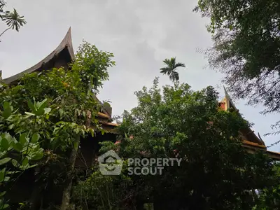 Charming traditional-style house surrounded by lush greenery, offering a serene and natural living environment.