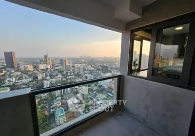 Stunning high-rise balcony with panoramic city skyline view at sunset.