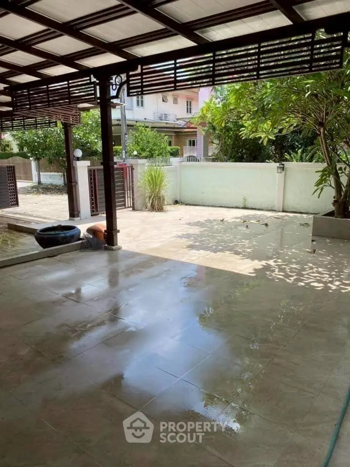 Spacious covered patio with garden view in a serene residential area.