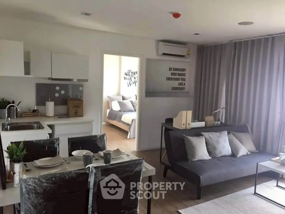 Modern open-plan living room with kitchen and cozy bedroom view