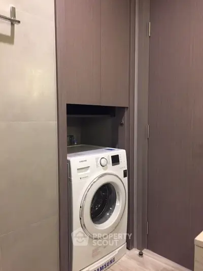 Modern bathroom with built-in washing machine and sleek cabinetry