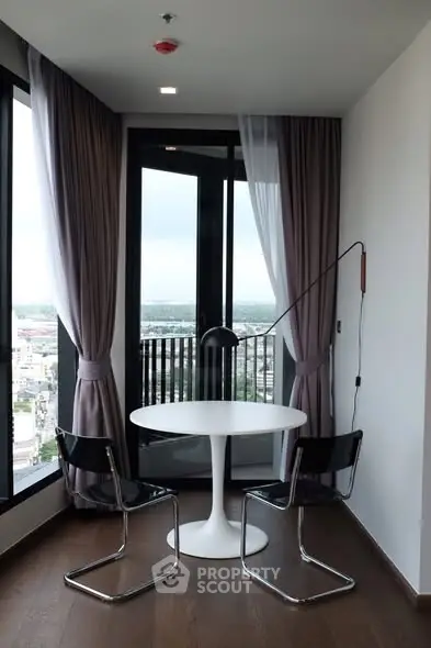 Chic modern balcony with city view, stylish chairs, and elegant curtains