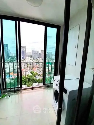 Stunning city view from high-rise balcony with washing machine, perfect for urban living.