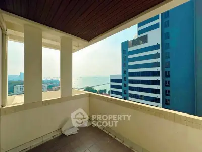 Spacious balcony with stunning city and sea view in modern high-rise building.