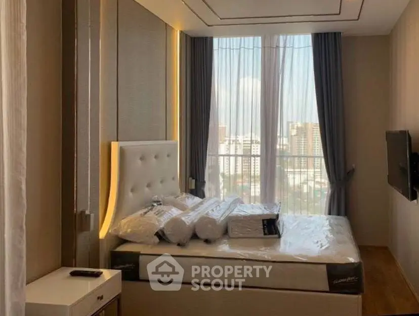 Luxurious bedroom with floor-to-ceiling windows and modern decor in a high-rise apartment.