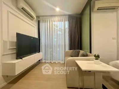 Modern living room with sleek design, featuring a wall-mounted TV, air conditioning, and stylish furniture.