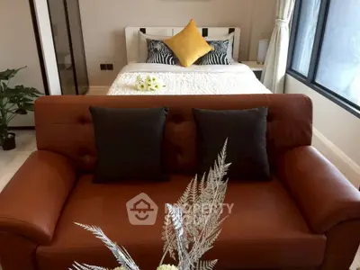 Cozy bedroom with stylish decor and comfortable seating area, perfect for relaxation.