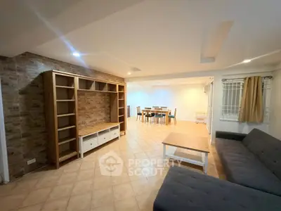 Spacious living room with modern furniture and dining area, perfect for family gatherings.
