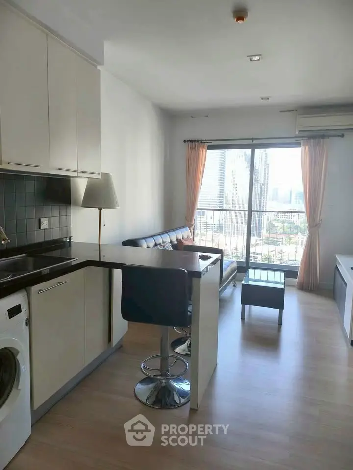 Modern open-plan living room with city view and sleek kitchen design.
