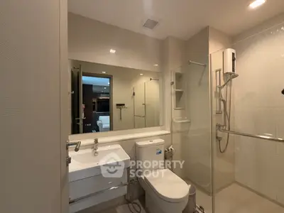 Modern bathroom with glass shower and sleek fixtures in a contemporary apartment.
