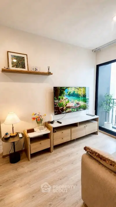 Modern living room with wooden furniture and large TV, featuring a cozy ambiance and balcony access.