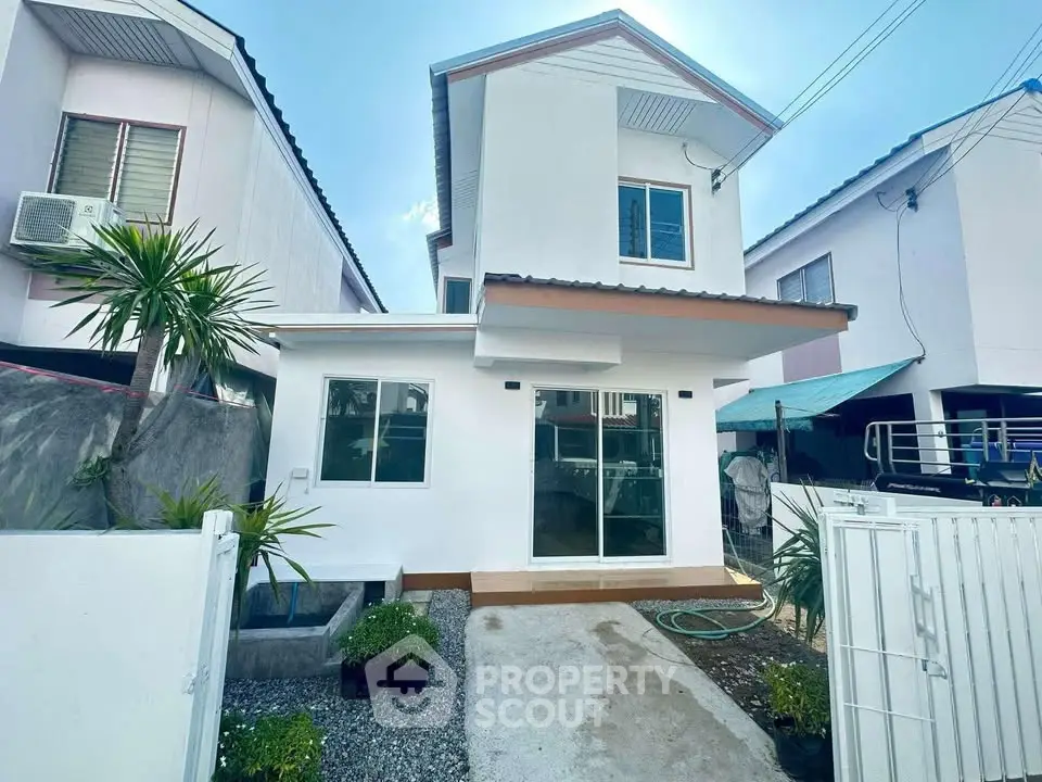 Charming two-story white house with modern design and small garden in a serene neighborhood.