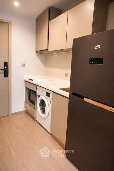 Modern kitchen with sleek appliances and ample storage in compact layout.