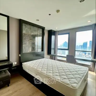Modern bedroom with city view and stylish decor in high-rise apartment.