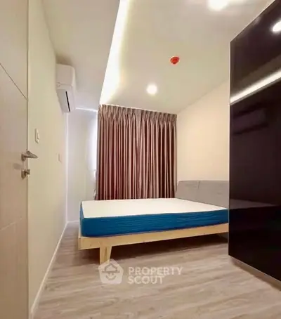 Modern bedroom with minimalist design, featuring a sleek bed and elegant curtains.