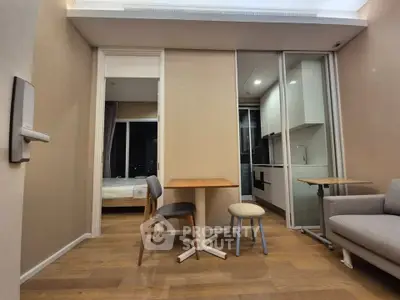 Modern apartment interior with open layout, featuring a cozy living area and compact kitchen.