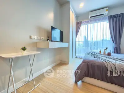 Modern bedroom with balcony view, featuring sleek furniture and natural light.