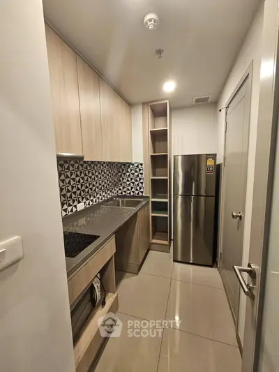 Modern kitchen with sleek cabinetry and stainless steel appliances in a compact layout.