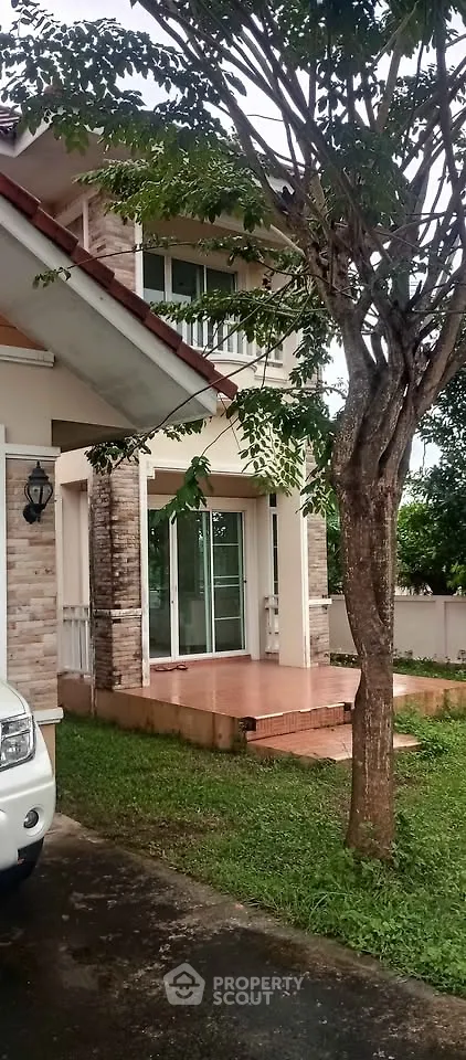 Charming two-story house with lush garden and spacious driveway, perfect for family living.