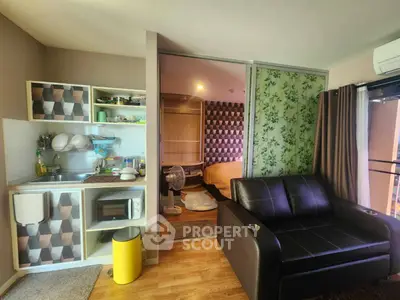 Modern studio apartment with open kitchen and cozy living area, featuring stylish decor and natural light.