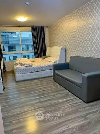 Spacious bedroom with modern decor and large window offering natural light.