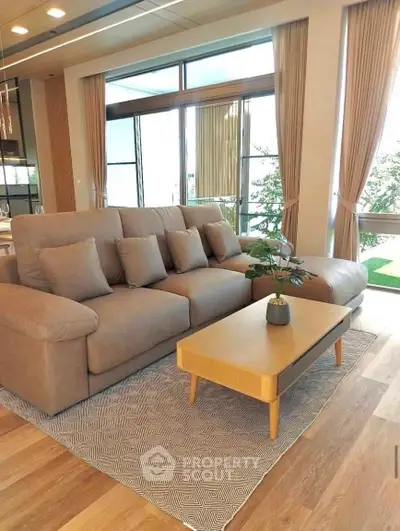 Luxurious living room with modern sofa and large windows offering a stunning view, perfect for relaxation.