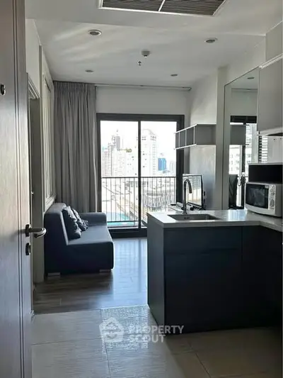Modern apartment with open kitchen and city view balcony, featuring sleek design and natural light.