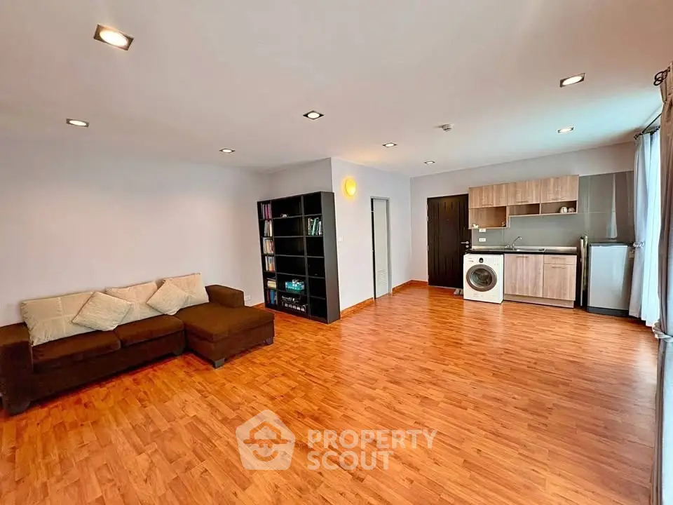 Spacious open-plan living room with modern kitchen and hardwood floors
