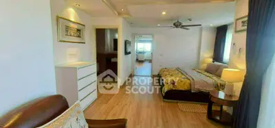 Spacious bedroom with elegant decor and natural light, featuring a cozy seating area and modern furnishings.