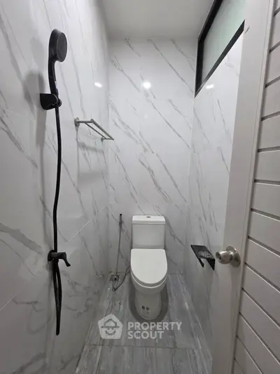 Compact modern bathroom with marble tiles and sleek fixtures