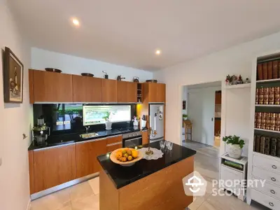 Modern kitchen with wooden cabinets and central island, equipped with high-end appliances and stylish lighting, perfect for culinary enthusiasts.