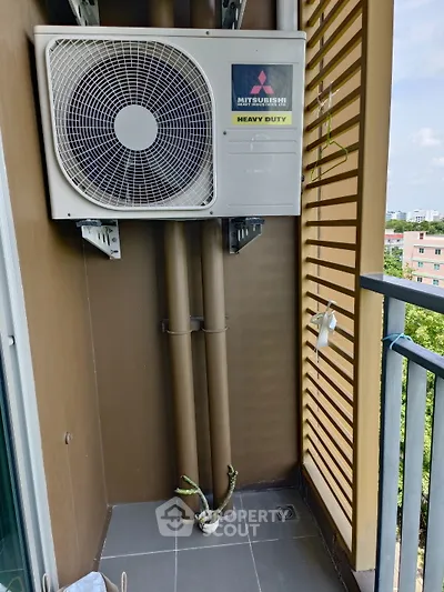Compact balcony with air conditioning unit and city view, ideal for urban living.