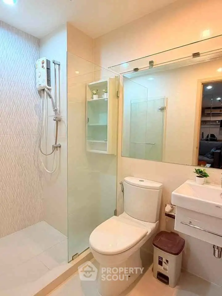 Modern bathroom with glass shower, sleek fixtures, and bright lighting.