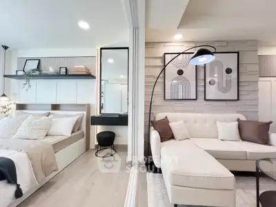 Modern open-concept living room and bedroom with stylish decor and neutral tones.